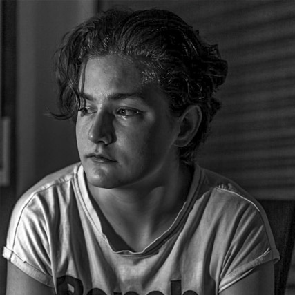Schwarz-weißes Porträt einer nachdenklichen jungen Person als Symbol für psychische Belastung in der Adoleszenz.